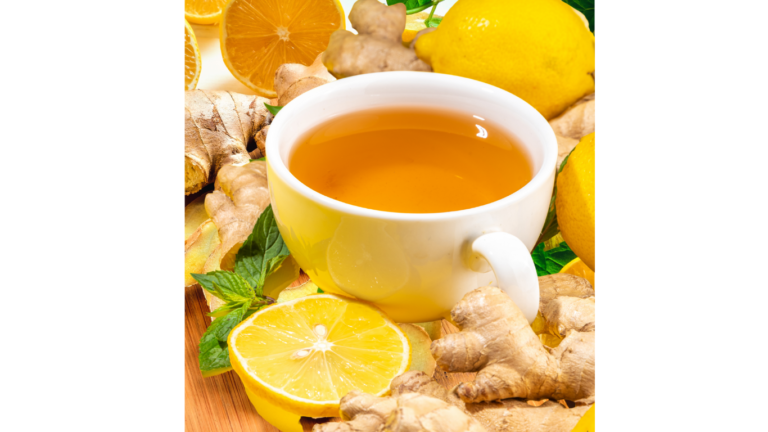 Glass of fresh lemon ginger drink with sliced lemon and ginger root, served in a clear glass on a bright, natural background.